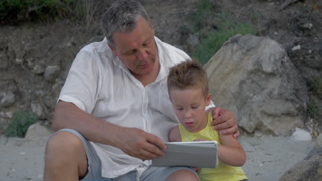 grandson and grandfather with touch pad outdoor