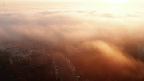 Volar-Sobre-La-Ciudad-De-La-Mañana.-Visibilidad-Limitada-Debido-A-Niebla-O-Nubes-Bajas-Y-Sol-Naciente-Brillante.-Varsovia,-Polonia