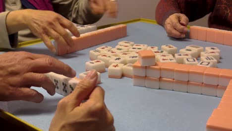 Close-up-of-anonymous-women's-hands-playing-Chinese-mahjong-at-home