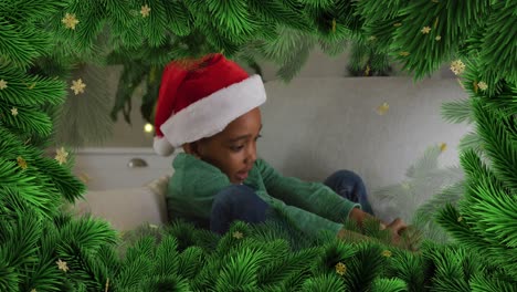 Animation-of-fir-tree-and-snowflakes-over-african-american-boy-wearing-santa-hat