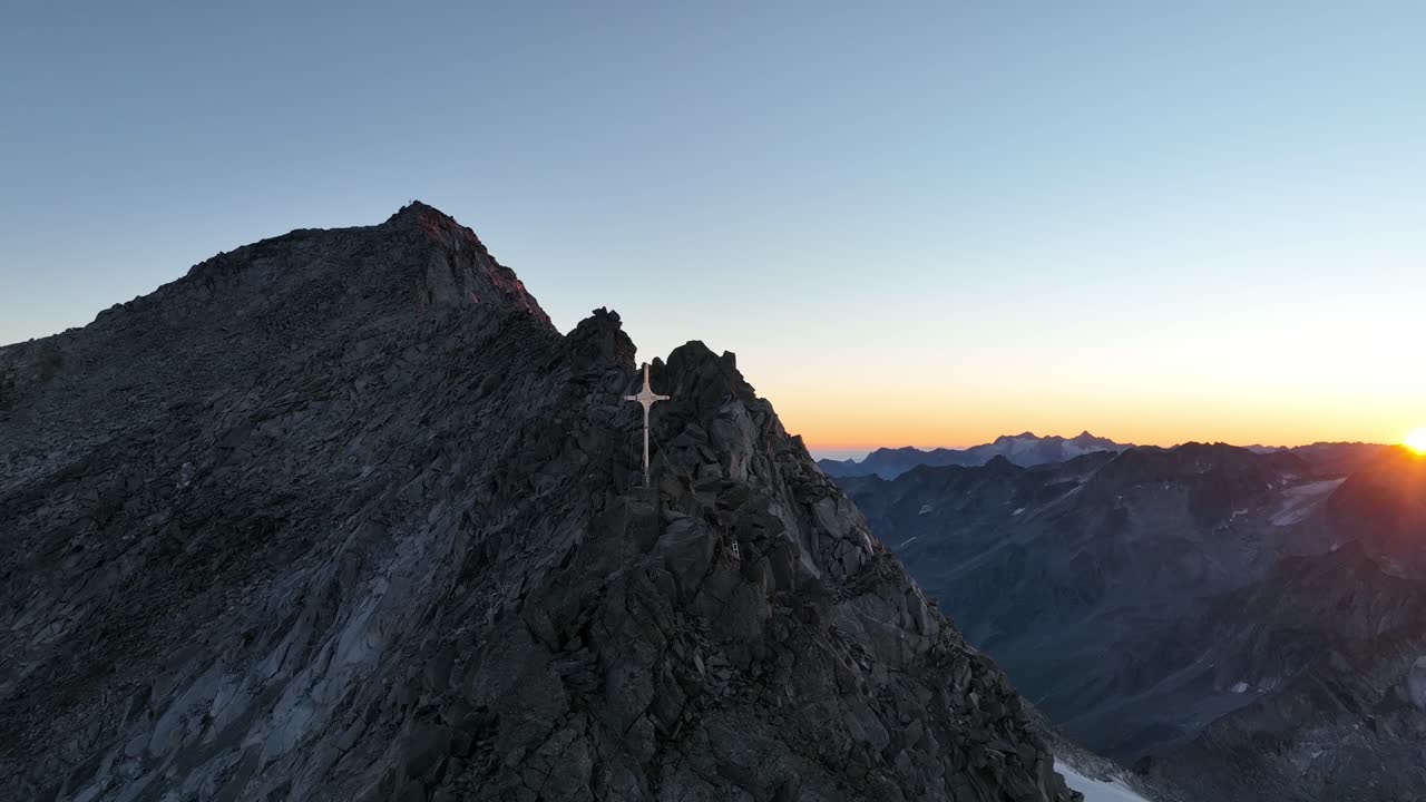 Drone footage of a rocky mountain top in the Alps at sunrise