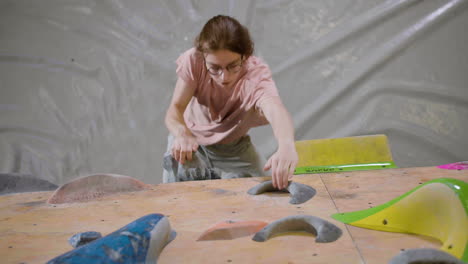 ragazzo adolescente che fa bouldering all'interno