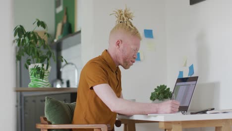 hombre albino afroamericano con rastas haciendo una videollamada en la computadora portátil