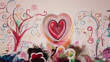 hand painted red heart mandala on colorfull hand painted wall by little girl with imagination and creativity