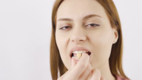 una mujer comiendo anacardos en primer plano.