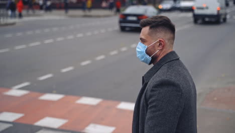 guy wearing safety mask and walking on a road. responsible behavior during world covid-19 pandemic.