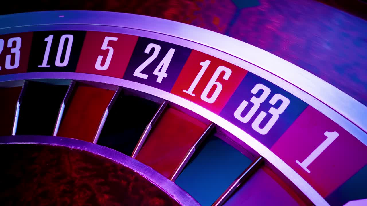 Billede fra et casino roulettehjul i bevægelse, kuglen stopper på 1 rød. Roulettehjul i gentagen rotation. Nærbillede af tal. Kameraet bevæger sig mod venstre i slowmotion