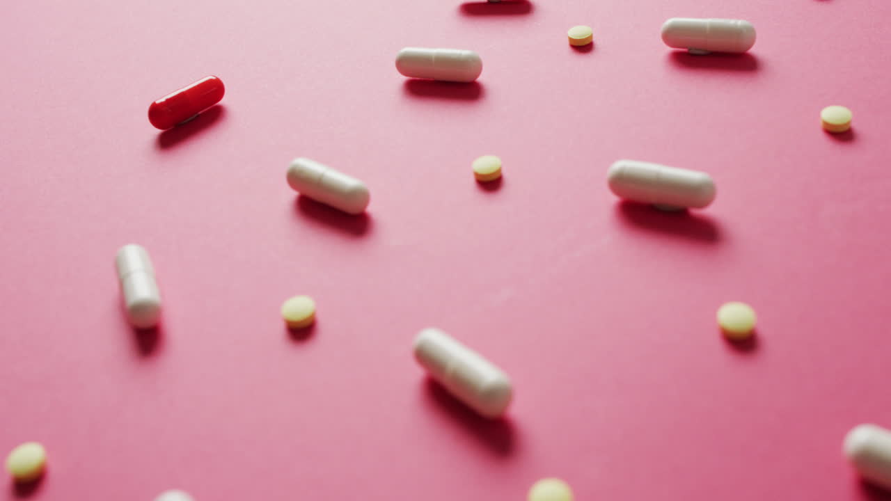 복사 공간과 함께 분홍색 배경에 배열 된 다양한 알약의 비디오