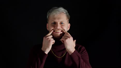 stylish young man looking at camera, feeling happiness, fun and enjoyment, showing smile gesture