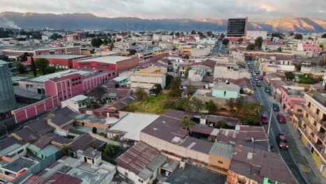 drone aerial view of urban colorful colonial neighborhood hill during golden hour sunset in quetzaltenango xela guatemala