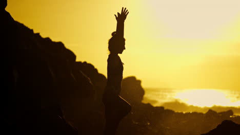 woman in yoga pose at sunset on the beach