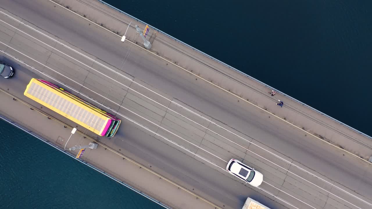 Aerial view. Two-way traffic on the bridge over the river. Close-up of city traffic