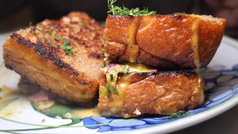 close-up of a stacked grilled cheese sandwich with melted cheese and sauce