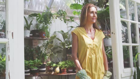 Woman-smiling-and-looking-at-camera-in-a-greenhouse
