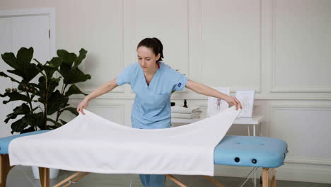 physiotherapist preparing massage bed