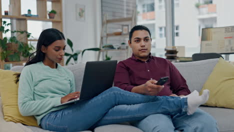 Remote-work,-sofa-and-a-couple-with-a-laptop