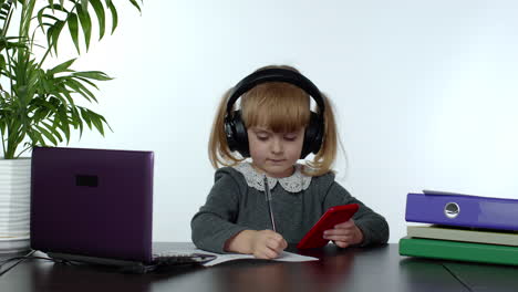 Teen-school-girl-wearing-wireless-headphones-calling-teacher-on-mobile-phone.-Distance-education