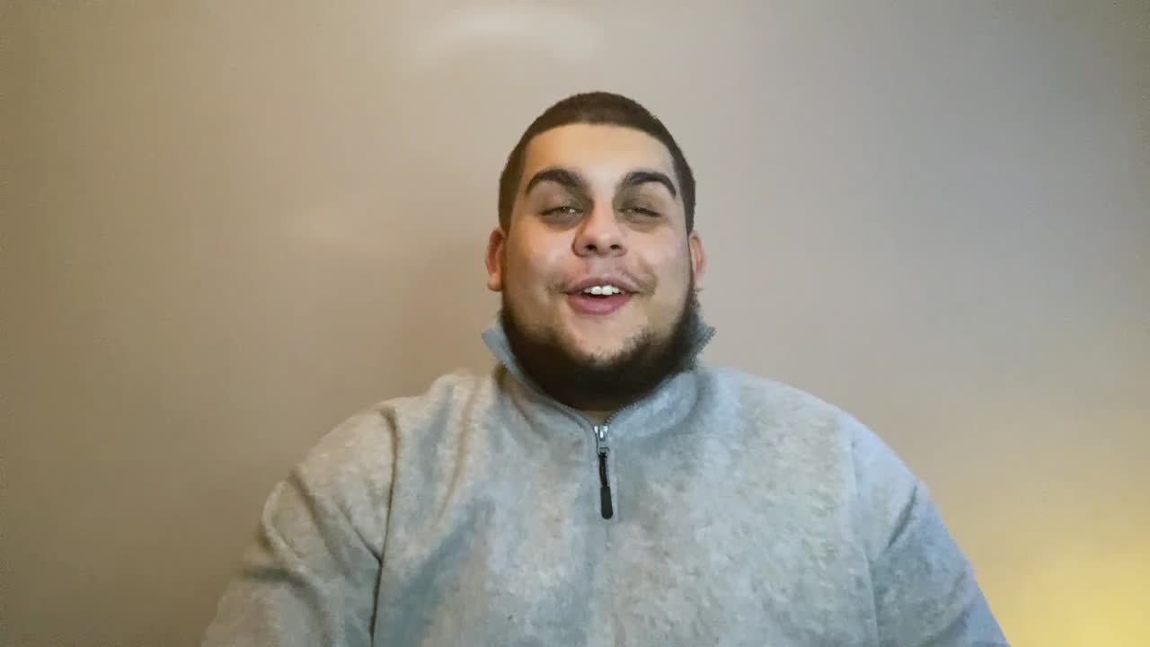 Young University Student Waving Hello and Greeting Directly to the Camera