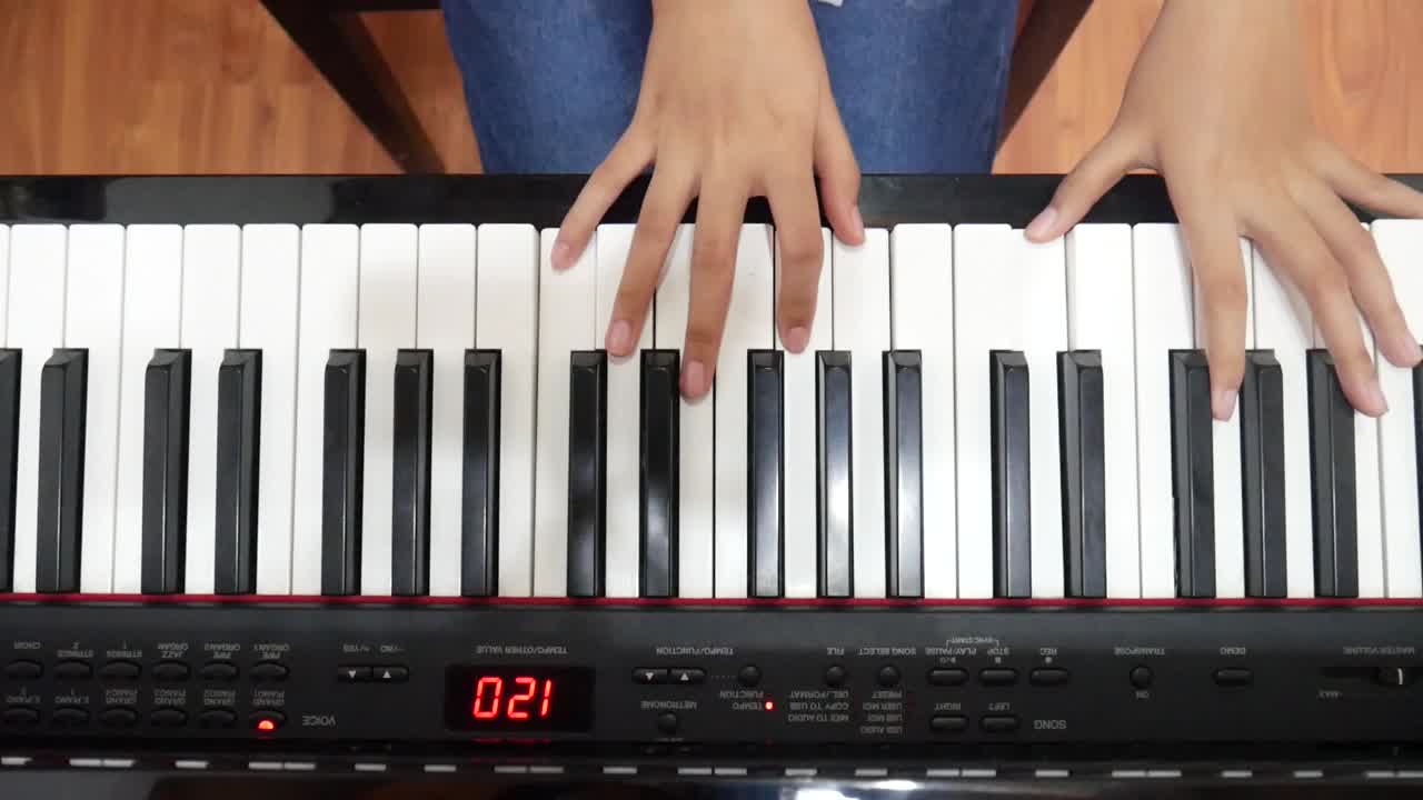 A girl's hand plays a piano. top view