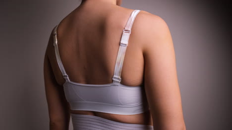 Close-Up-of-Female-Turning-Around-Wearing-White-Surgical-Bra-Post-Breast-Augmentation