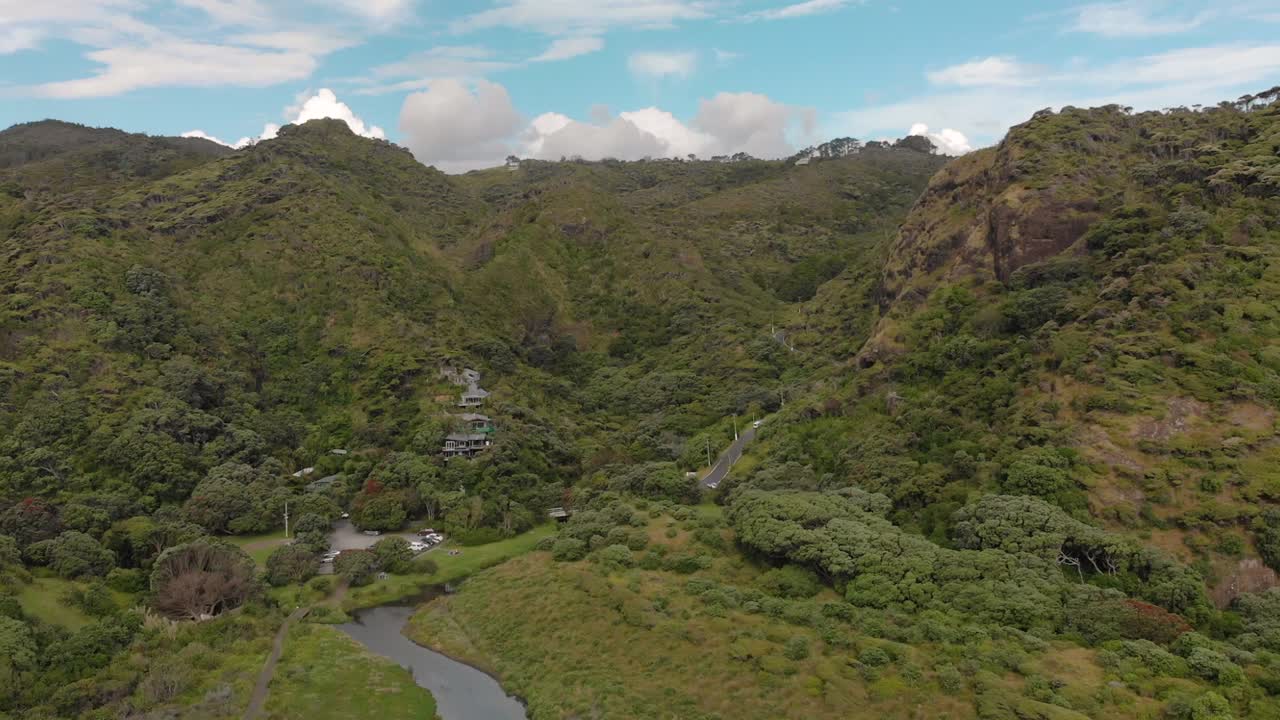 cámara lenta: vista aérea de casas de estilo de vida en colinas de nueva zelanda con bosques nativos