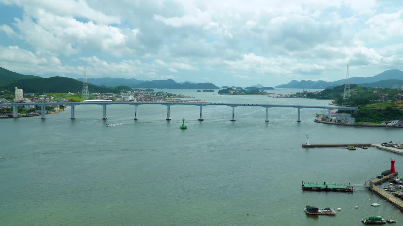 한국의 하늘에 흰 구름이 있는 잔잔한 바다 위의 거제교