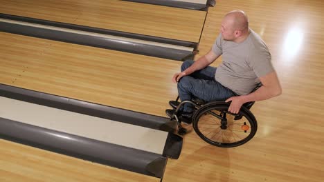 two young disabled men in wheelchairs playing bowling in the club