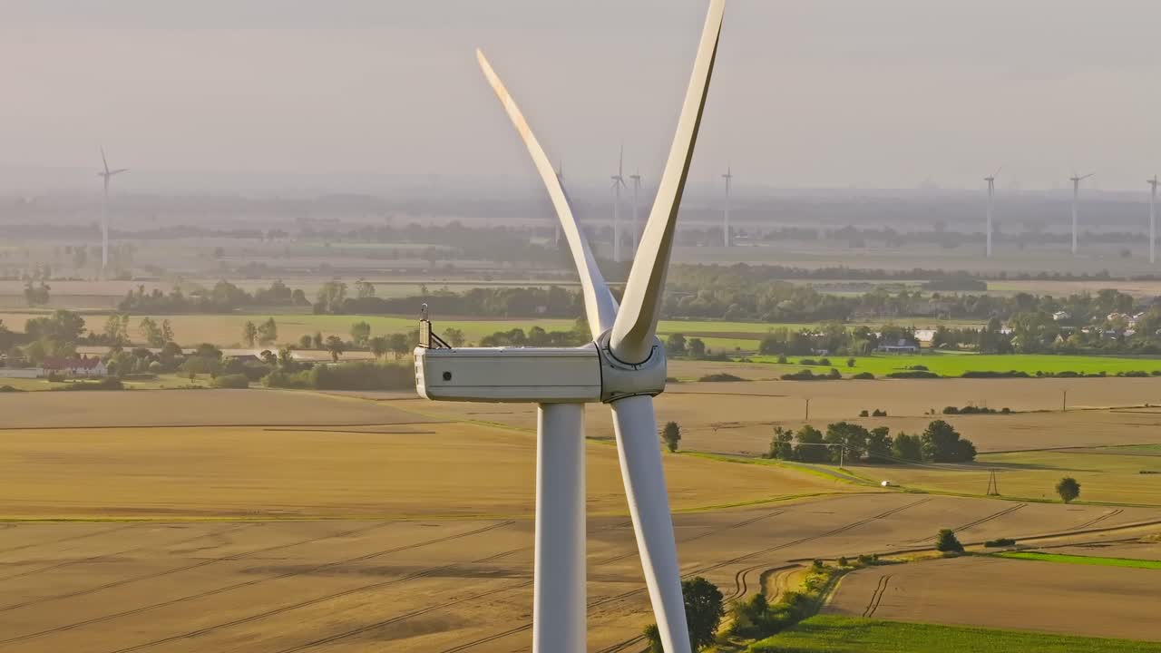 Aerial shot of renewable energy wind turbines in Polish countryside, warm sunset