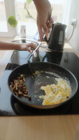 frying eggs and mushrooms in a pan