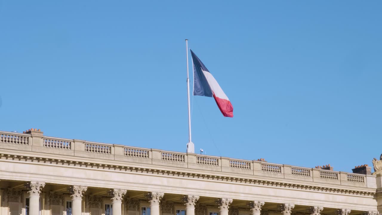 The French flag dances with the wind, glowing under the sunlight