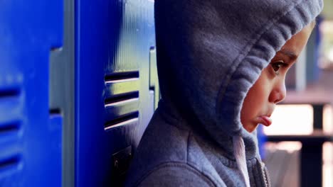 sad schoolboy standing in locker room 4k