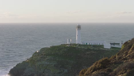 un faro blanco en un afloramiento rocoso