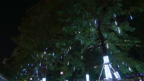 led lights cascading like water displayed on the trees by the sidewalk for the celebration of the christmas season in the city of bangkok, thailand