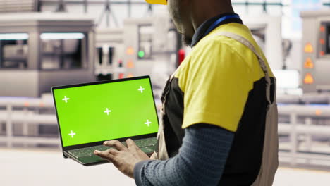 vertical video solar panels factory engineer analyzes performance data with green screen laptop