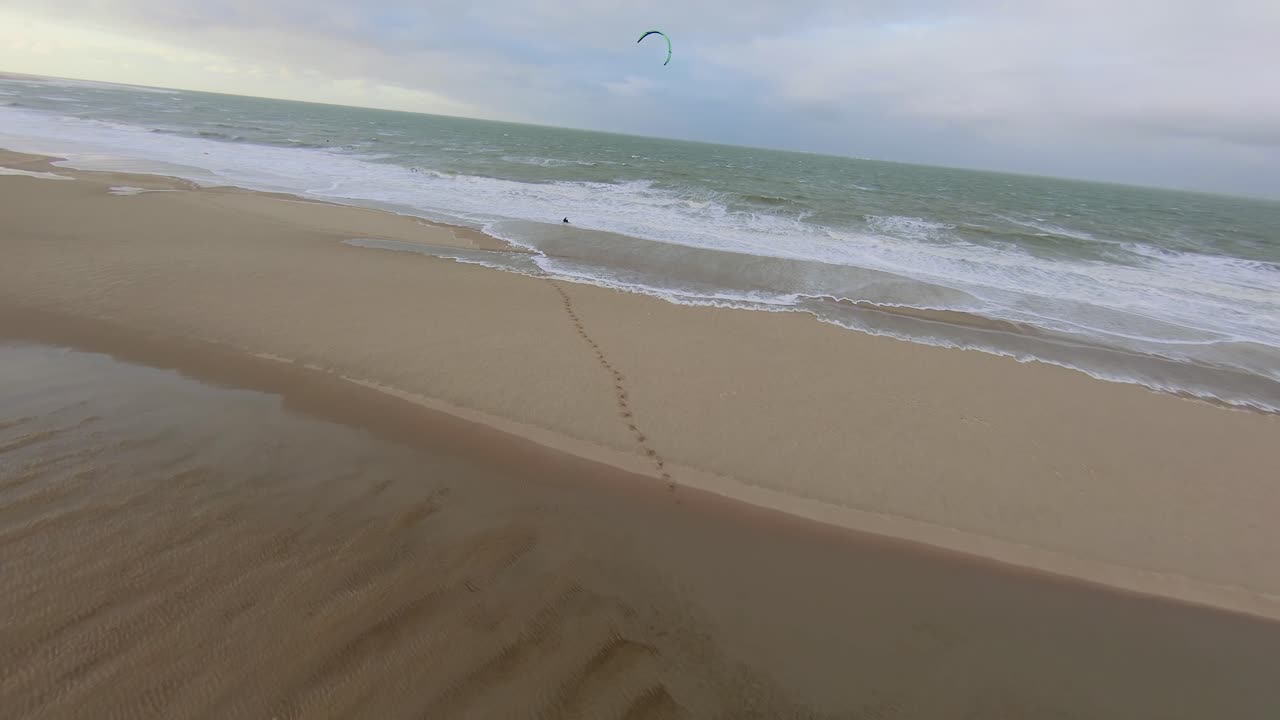 Drone flying fast towards a kitesurfer during a windy day