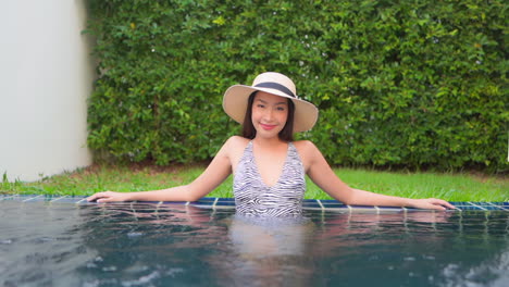sexy asian model relaxing in a pool smiling