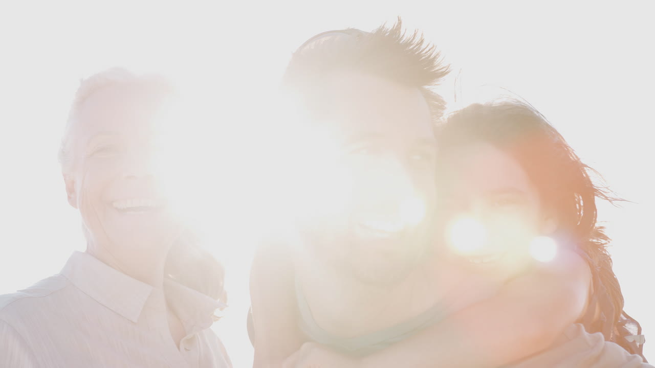 뜨거운 빛에 맞서 여름 해변 휴가를 보내는 다세대 가족의 야외 초상화