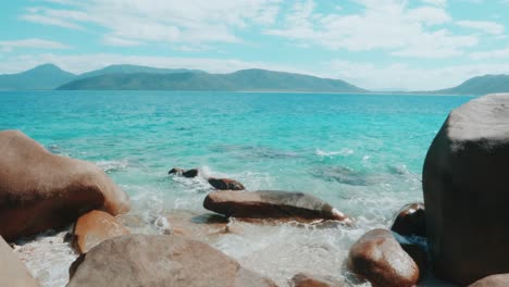 Beautiful-beach-with-rocks-and-colorful-blue-water-on-Fitzroy-Island-in-Queensland,-Australia