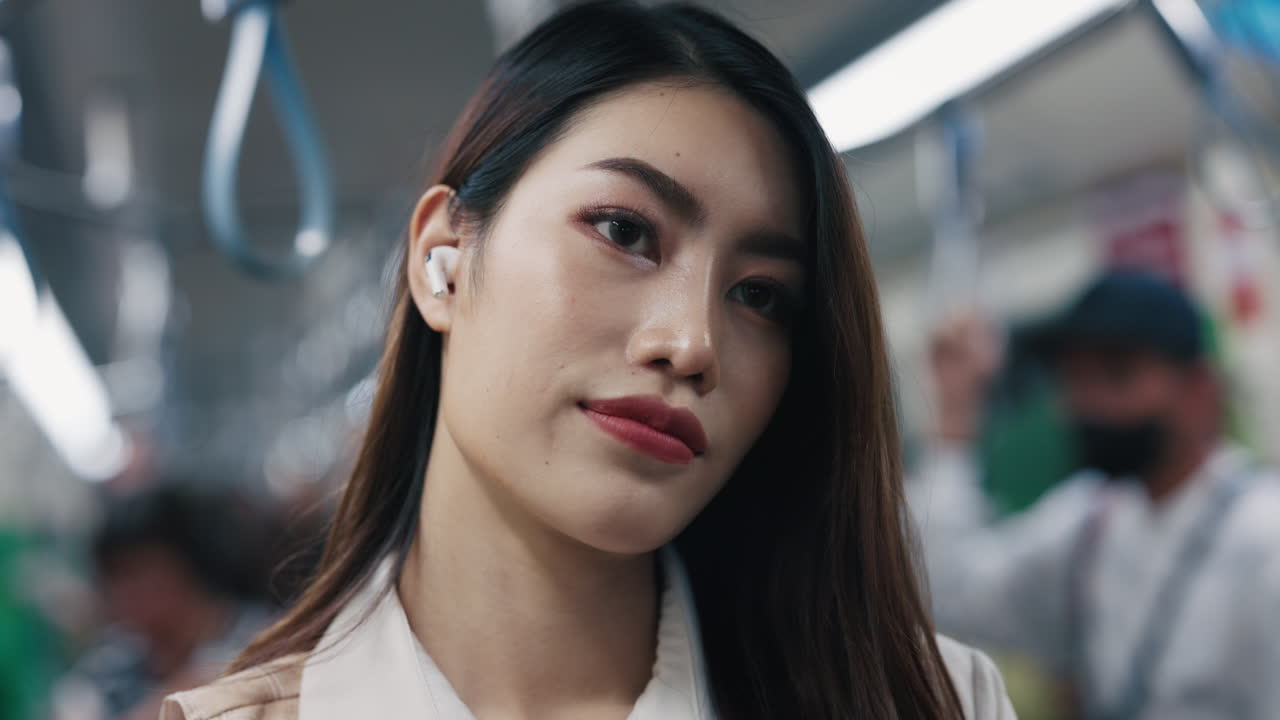 Woman using earbuds on a subway