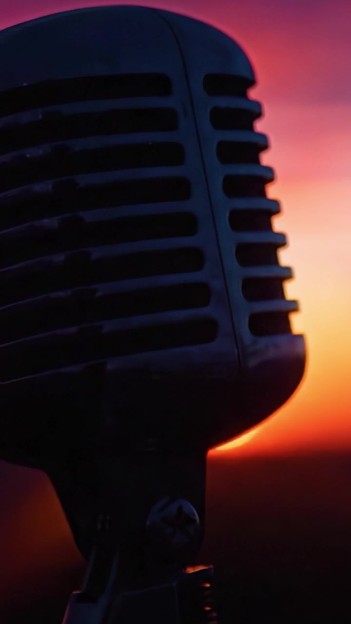 A Close-up of a Vintage Microphone Silhouetted by a Stunning Sunset, Capturing the Essence of Music and Expression in a Beautiful Outdoor Setting