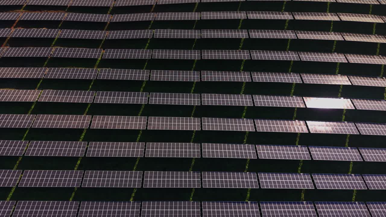 Solar panels arranged in rows on a clear day at a renewable energy site