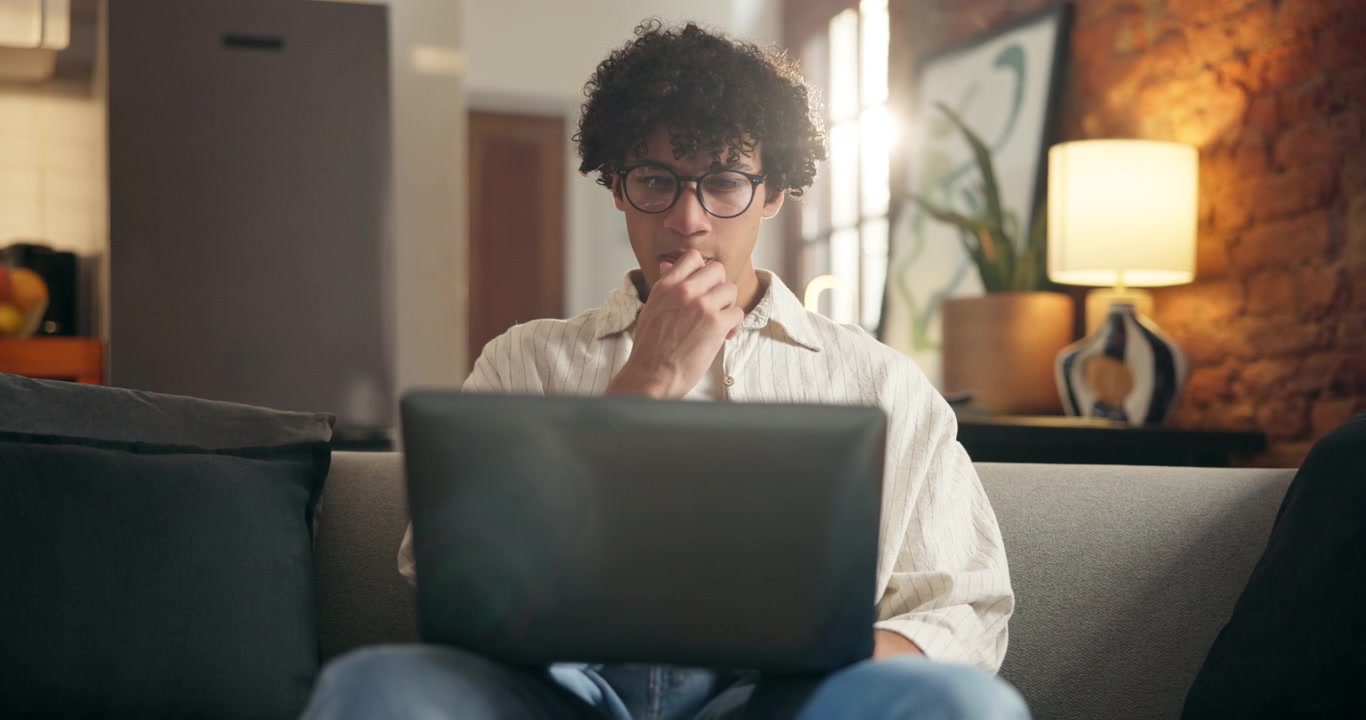 Ung mand, der arbejder på bærbar computer derhjemme
