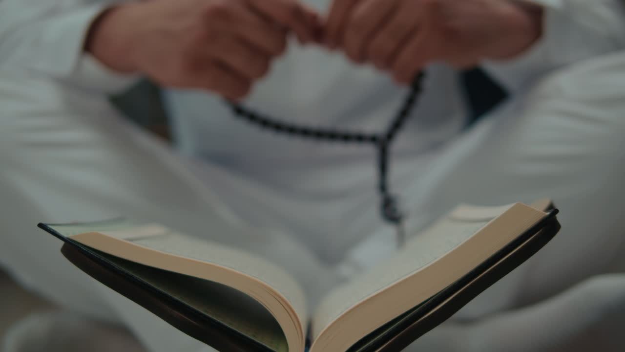 무슬림 남자 는 꾸란 과  rosary 와 함께 기도 하고 있다