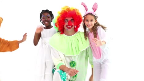 animation of red shapes over diverse happy children and clown having fun at party, on white, waving