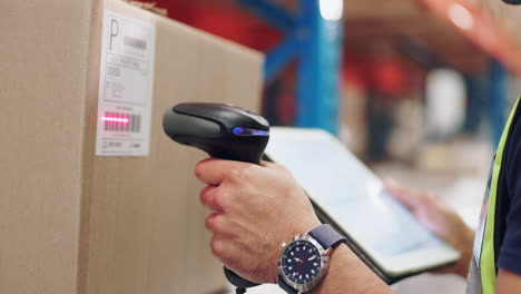 warehouse worker scanning barcode on package with tablet