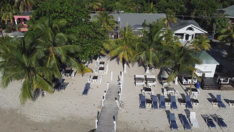 órbitas-Aéreas-Bajas-Sobre-Un-Soleado-Restaurante-De-Playa-De-Arena-Con-Palmeras