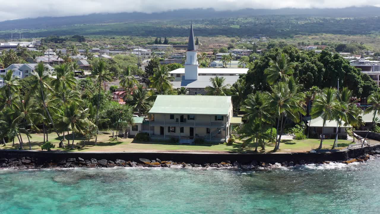 Aerial close-up panning shot of historic Hulihe'e Palace on the shores of Kailua-Kona, Hawai'i