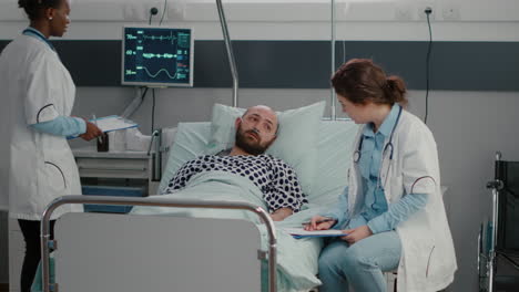 Sick-man-resting-in-bed-with-oxygen-tube-talking-with-doctor-explaining-disease-symptom