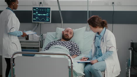 sick man resting in bed with oxygen tube talking with doctor explaining disease symptom