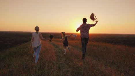 a cheerful family runs joyfully towards the sun emotionally waving backpacks and a bouquet of flower